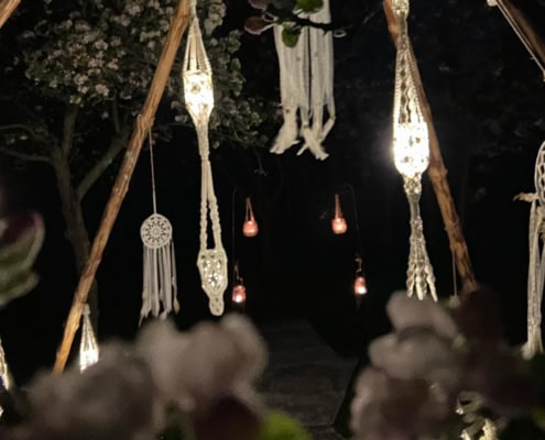 Gemütliches Tipi mit Makramee-Lounge, Lichterketten und Traumfängern Gemütliches Ambiente in der Makramee-Lounge im Garten mit, Lichterketten und Traumfängern für eine magische Atmosphäre.